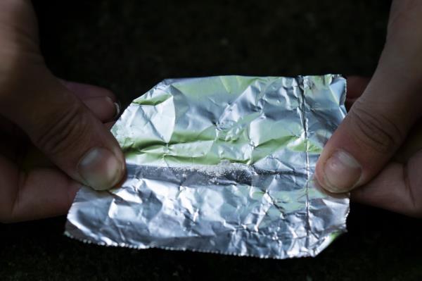 A homeless individual preparing to smoke fentanyl in a downtown Portland park on June 28, 2024.