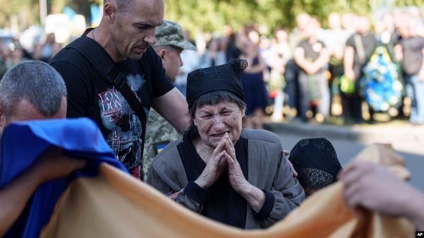 A mother cries near the coffin of her son killed by a Russian rocket attack at a Ukrainian military academy, during his funeral ceremony in Poltava, Ukraine, Sept. 7, 2024. 
