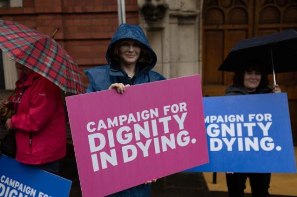 A campaigner with a sign for assisted dying saying dignity in dying. 