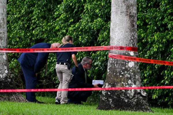 Law enforcement officials work at the crime scene outside the Trump International Golf Club in West Palm Beach, Florida